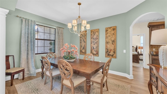6372 English Creek Dr, Lakeland, FL 33811 - dining room featuring light wood-style floors, a chandelier, and arched walkways