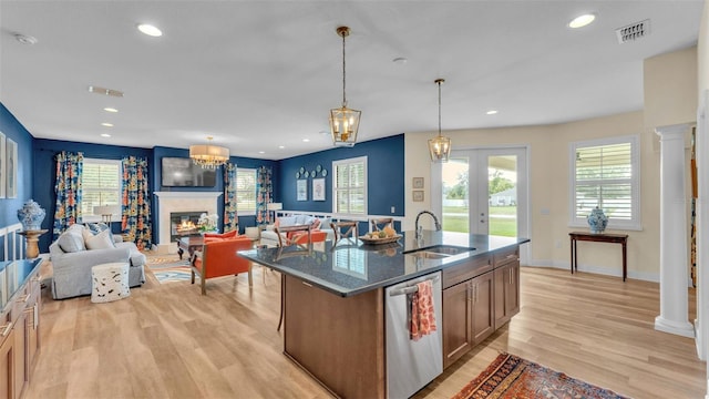 6372 English Creek Dr, Lakeland, FL 33811 - kitchen featuring stainless steel dishwasher, a glass covered fireplace, light wood-type flooring, recessed lighting, and dark stone countertops