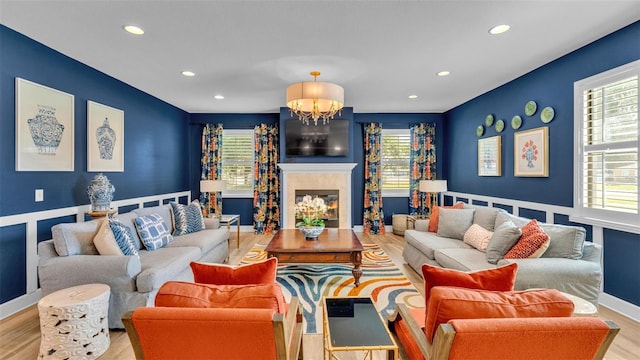 6372 English Creek Dr, Lakeland, FL 33811 - living room featuring wood finished floors, healthy amount of natural light, recessed lighting, a chandelier, and a glass covered fireplace