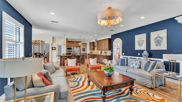 6372 English Creek Dr, Lakeland, FL 33811 - living room featuring arched walkways, a chandelier, light wood-style floors, and recessed lighting