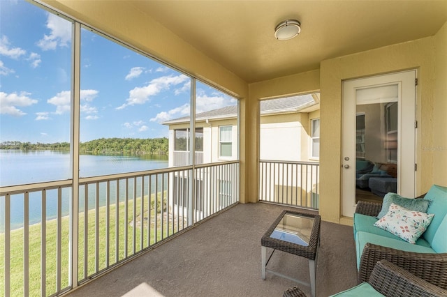 sunroom / solarium with a water view and carpet flooring
