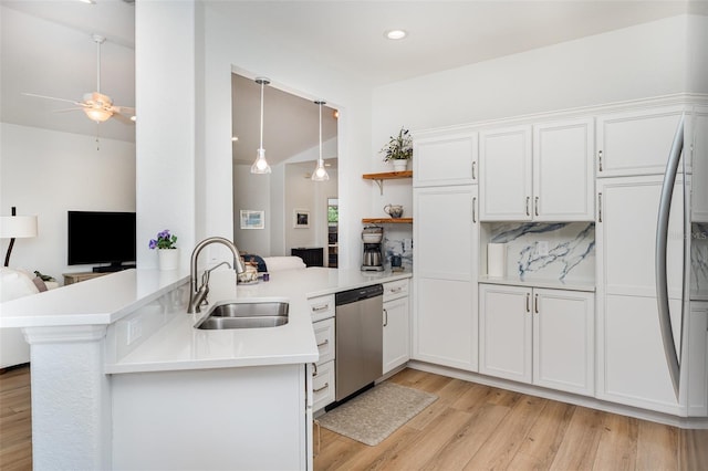 kitchen with a sink, light wood-type flooring, ceiling fan, light countertops, and stainless steel dishwasher
