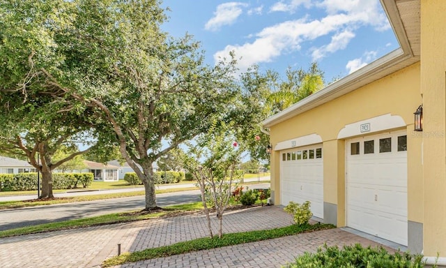 garage with decorative driveway