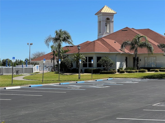 view of property featuring fence and uncovered parking
