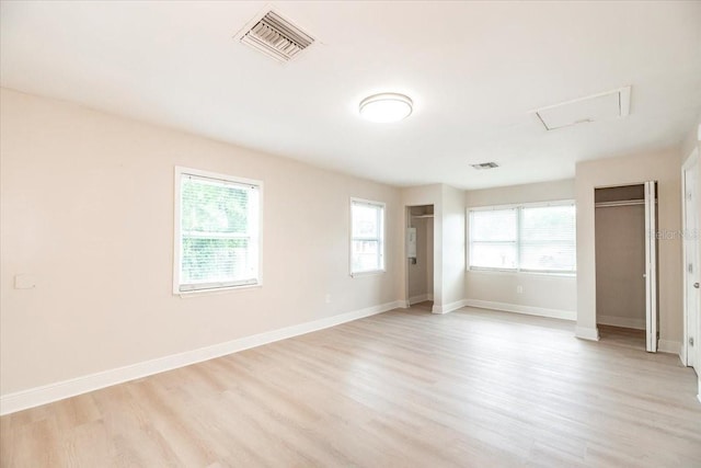empty room with visible vents, baseboards, and light wood finished floors