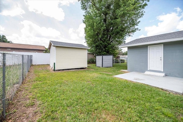 view of yard featuring a storage shed, a fenced backyard, an outdoor structure, and a patio