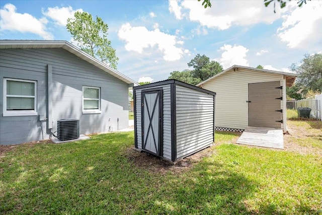 view of shed featuring central AC unit and fence