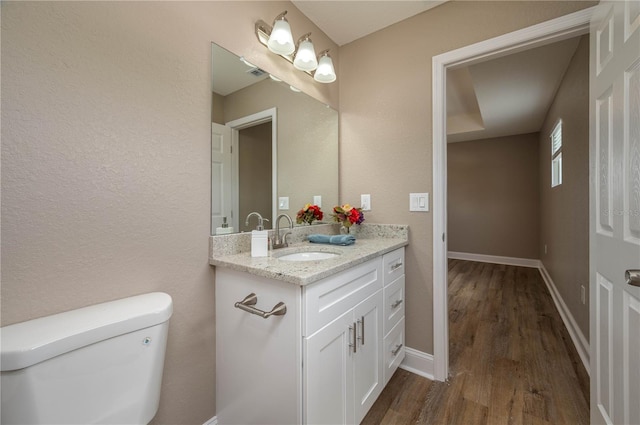4189 Radford Rd, Bartow, FL 33830 - half bath featuring toilet, vanity, wood finished floors, baseboards, and a textured wall