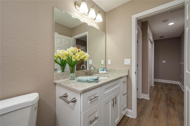 4189 Radford Rd, Bartow, FL 33830 - bathroom featuring toilet, vanity, wood finished floors, a textured wall, and baseboards