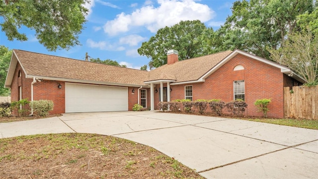 single story home with a shingled roof, an attached garage, a chimney, brick siding, and driveway