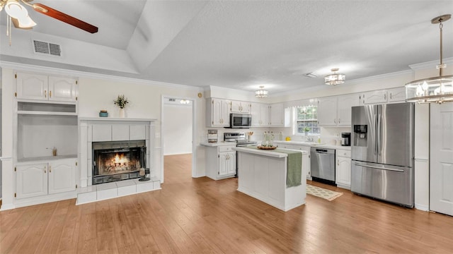 kitchen featuring visible vents, ceiling fan with notable chandelier, light wood-type flooring, and stainless steel appliances