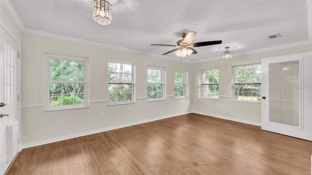 spare room featuring visible vents, a ceiling fan, hardwood / wood-style flooring, crown molding, and radiator heating unit