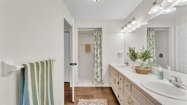 full bath featuring double vanity, a shower with curtain, a sink, and wood finished floors