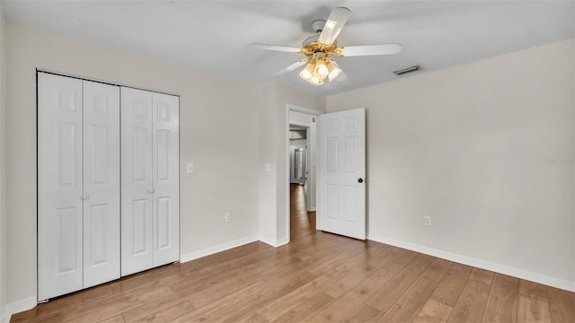 unfurnished bedroom with a closet, baseboards, a ceiling fan, visible vents, and light wood finished floors