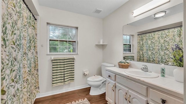 bathroom with visible vents, baseboards, toilet, vanity, and wood finished floors