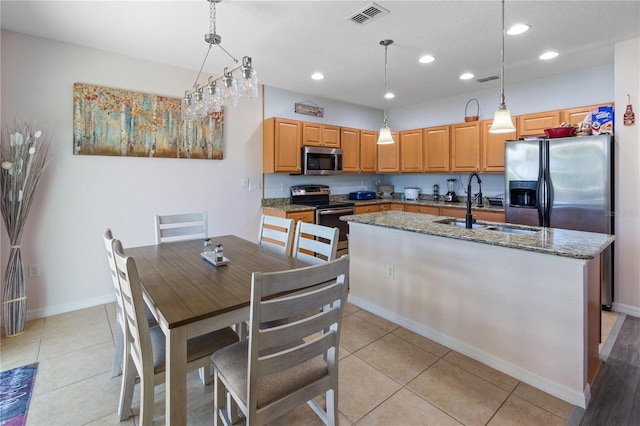 kitchen featuring visible vents, a sink, appliances with stainless steel finishes, recessed lighting, and a center island with sink