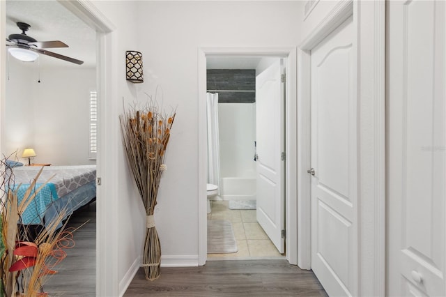 hallway featuring baseboards and wood finished floors