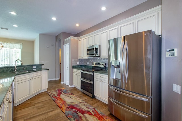 6626 Royal Forest Dr, Lakeland, FL 33811 - kitchen featuring light wood-style flooring, recessed lighting, a sink, stainless steel appliances, and backsplash