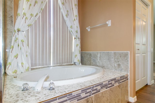 6626 Royal Forest Dr, Lakeland, FL 33811 - bathroom featuring a garden tub and wood finished floors