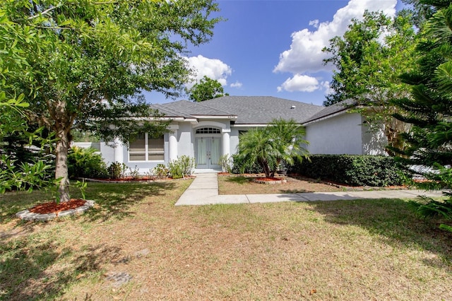 6626 Royal Forest Dr, Lakeland, FL 33811 - view of front of home featuring roof with shingles, a front lawn, and stucco siding