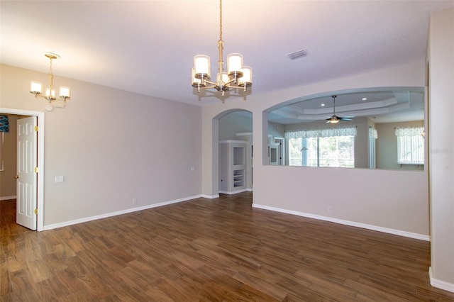 6626 Royal Forest Dr, Lakeland, FL 33811 - empty room featuring ceiling fan with notable chandelier, a tray ceiling, arched walkways, visible vents, and wood finished floors