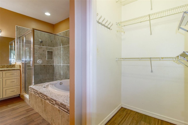 6626 Royal Forest Dr, Lakeland, FL 33811 - full bathroom featuring a walk in closet, a bath, a shower stall, and wood finished floors