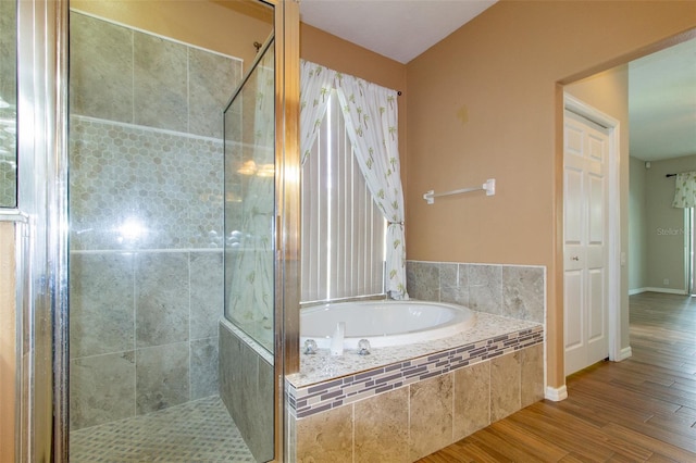 6626 Royal Forest Dr, Lakeland, FL 33811 - bathroom featuring baseboards, a garden tub, a stall shower, and wood finished floors