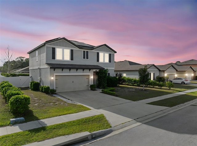4886 St James Ln, Winter Haven, FL 33881 - view of front facade featuring an attached garage, driveway, a gate, board and batten siding, and solar panels