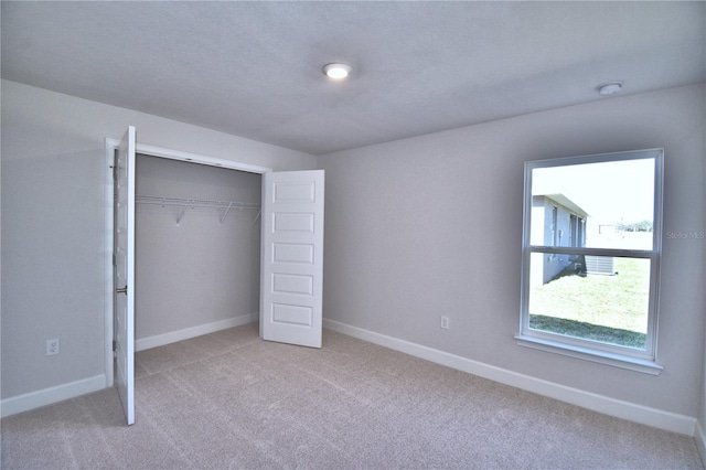 unfurnished bedroom featuring baseboards, a closet, and carpet floors