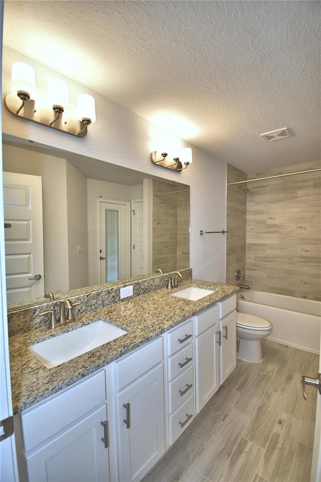full bath with visible vents, a sink, toilet, and wood tiled floor