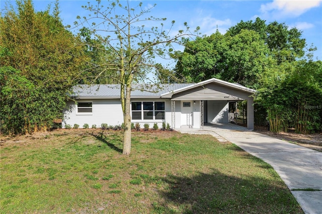 ranch-style house with a carport, a front yard, metal roof, and driveway