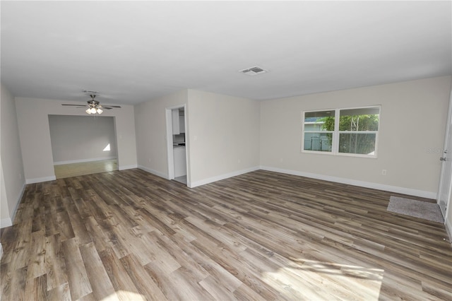 empty room with visible vents, baseboards, ceiling fan, and wood finished floors
