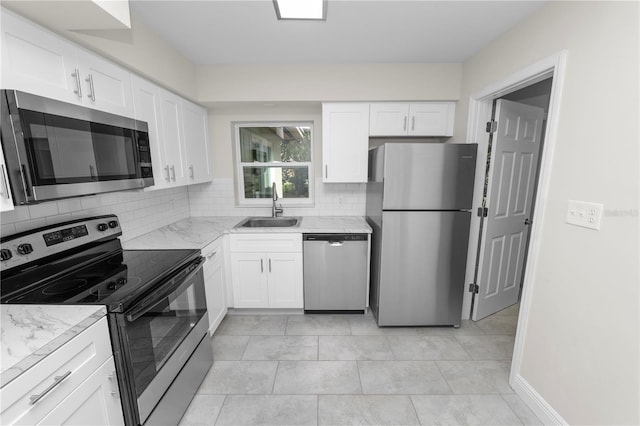 kitchen with a sink, tasteful backsplash, appliances with stainless steel finishes, and white cabinets
