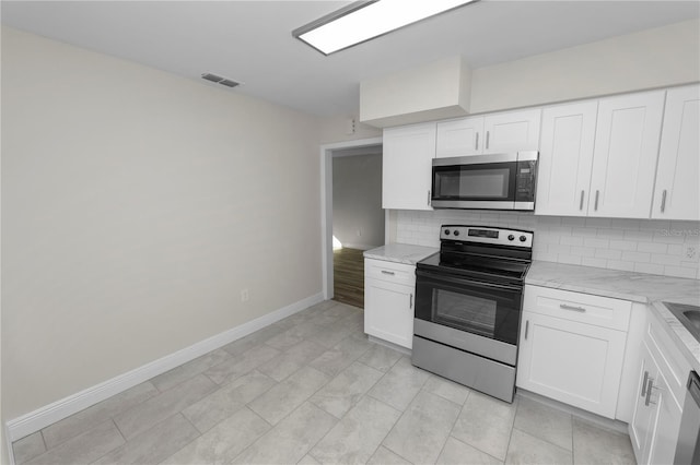 kitchen featuring visible vents, backsplash, white cabinets, and stainless steel appliances