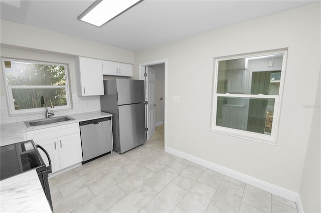 kitchen featuring white cabinets, light countertops, a sink, and appliances with stainless steel finishes