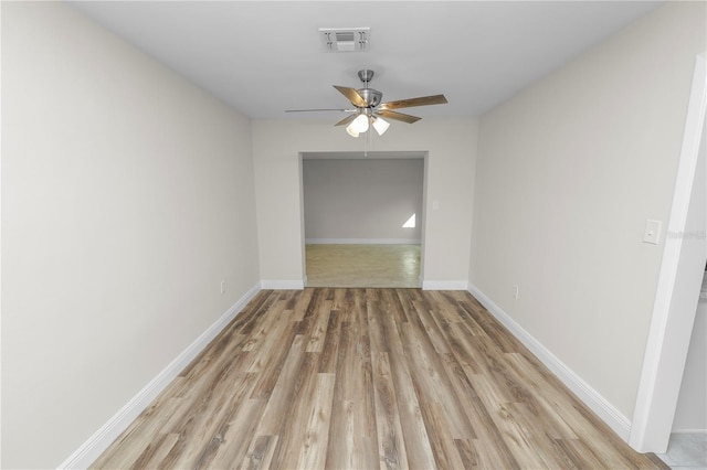 spare room featuring light wood-style flooring, visible vents, baseboards, and a ceiling fan