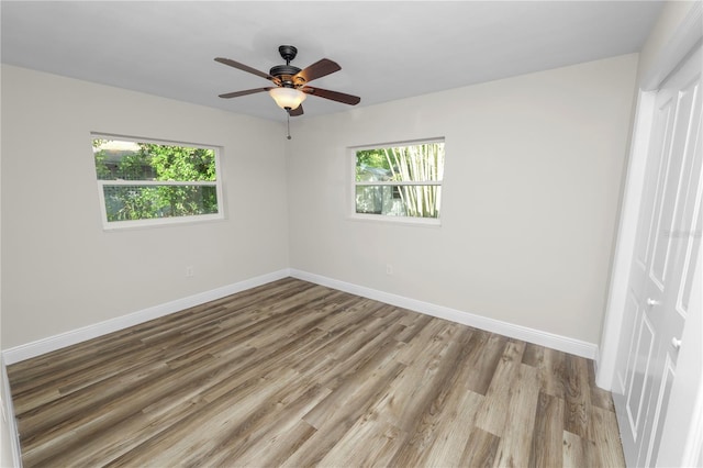 unfurnished room with wood finished floors, baseboards, and a wealth of natural light