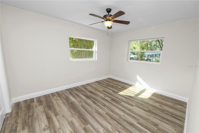 unfurnished room featuring wood finished floors, ceiling fan, and baseboards