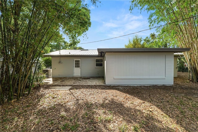 rear view of house with metal roof and a patio