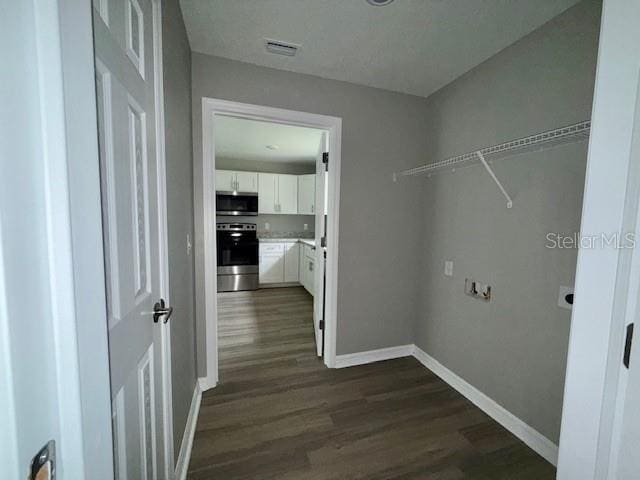 laundry area featuring dark wood-style floors, baseboards, and visible vents