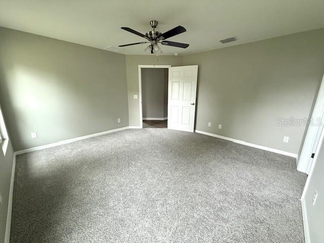 unfurnished bedroom with visible vents, baseboards, ceiling fan, and carpet