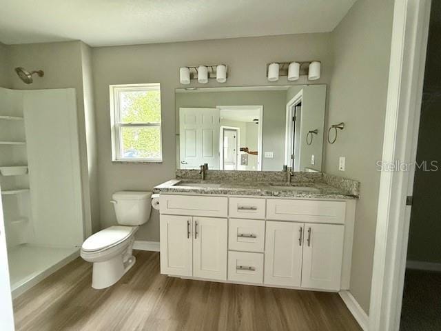 full bathroom with toilet, a stall shower, and wood finished floors