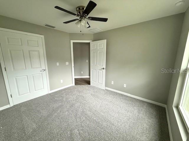 unfurnished bedroom with carpet flooring, baseboards, and a ceiling fan