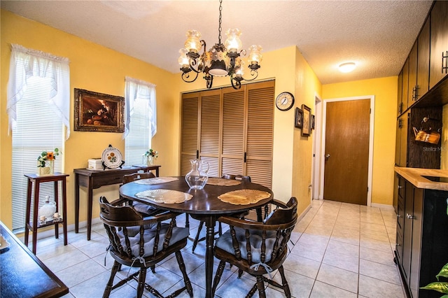4101 N Forbes Rd, Plant City, FL 33565 - dining room featuring a chandelier, a textured ceiling, light tile patterned floors, and baseboards