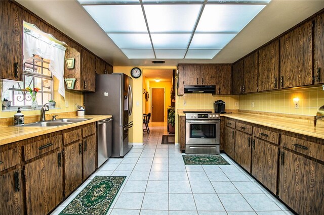 4101 N Forbes Rd, Plant City, FL 33565 - kitchen with stainless steel appliances, exhaust hood, a sink, decorative backsplash, and dark brown cabinetry