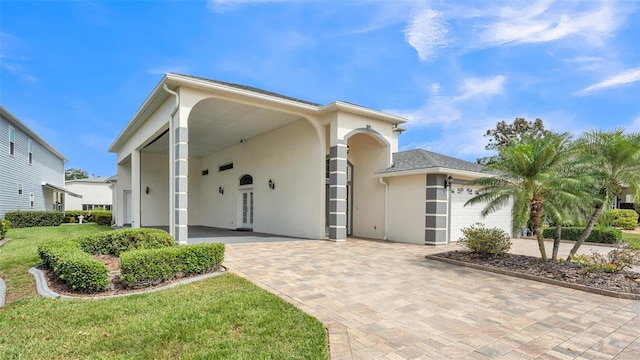 1062 Rally Dr, Polk City, FL 33868 - view of front of house with a front yard, an attached garage, driveway, and stucco siding