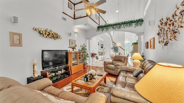 1062 Rally Dr, Polk City, FL 33868 - living room featuring arched walkways, ornate columns, a towering ceiling, a ceiling fan, and wood finished floors