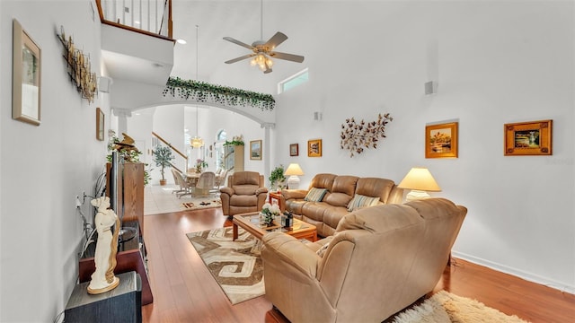 1062 Rally Dr, Polk City, FL 33868 - living room with arched walkways, a high ceiling, wood finished floors, and a ceiling fan