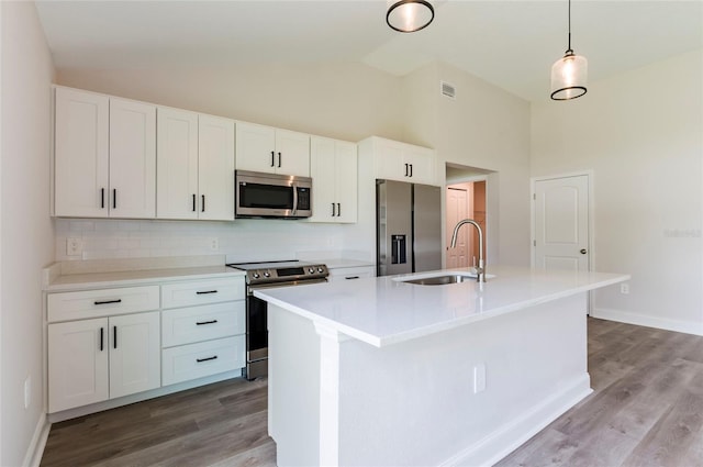 kitchen with an island with sink, visible vents, appliances with stainless steel finishes, light wood finished floors, and a sink