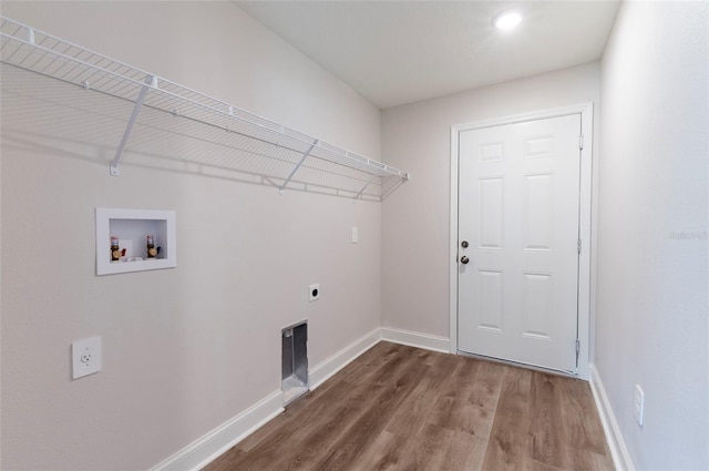 clothes washing area featuring baseboards, electric dryer hookup, wood finished floors, and laundry area